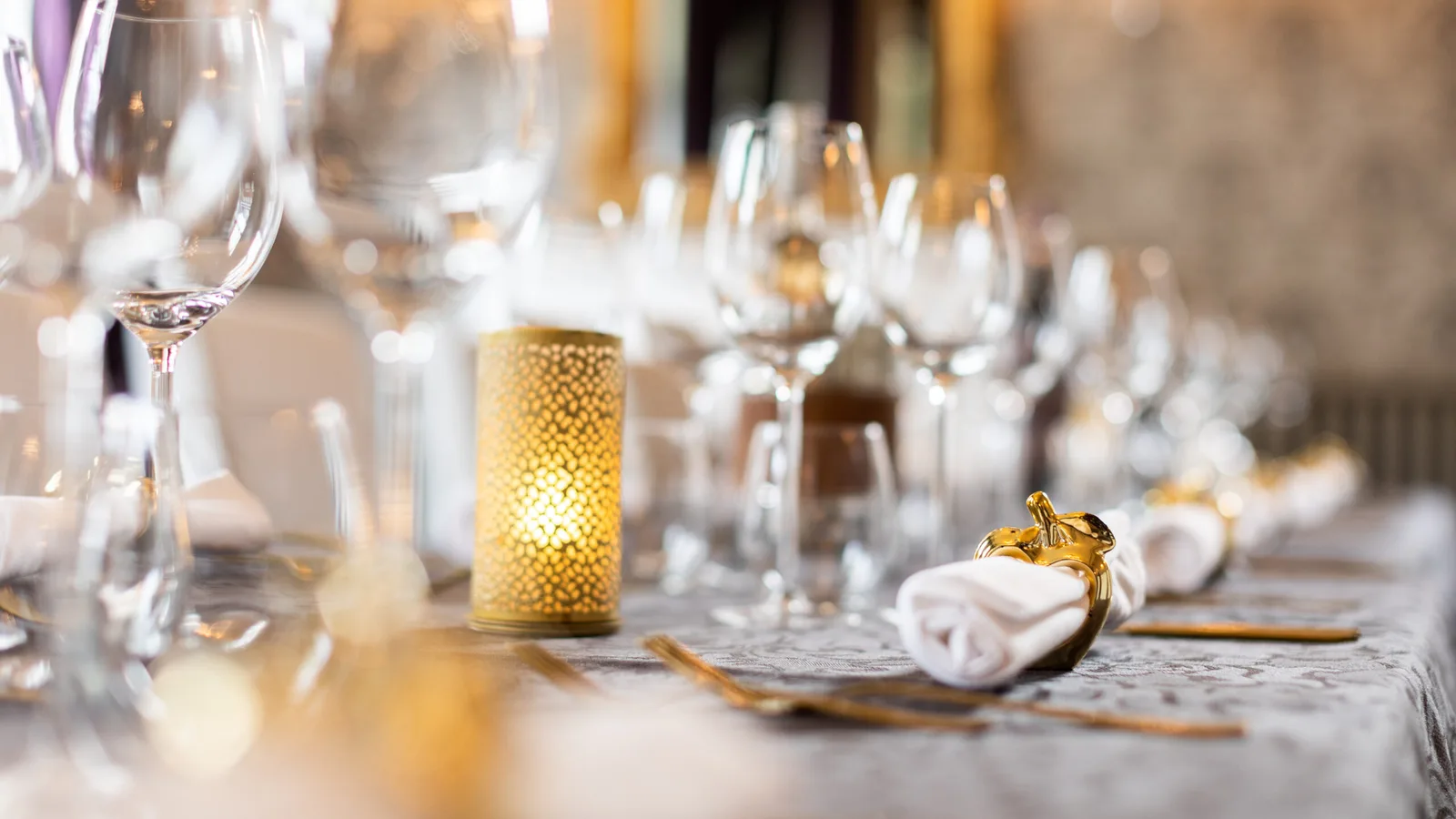 Een feestelijk gedekte tafel met glaswerk en kaarslicht