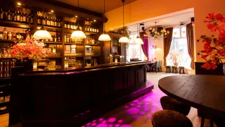 De houten bar en kroonluchters van de Brasserie bij De Appel 2.0